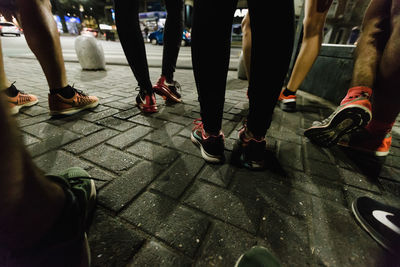 Low section of people walking on footpath at night