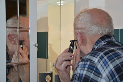 Rear view of man with reflection on mirror