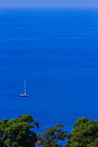 Sailboat sailing on sea against blue sky