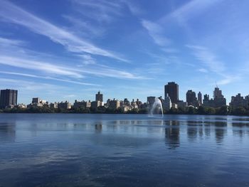 Scenic view of river by buildings against sky in city