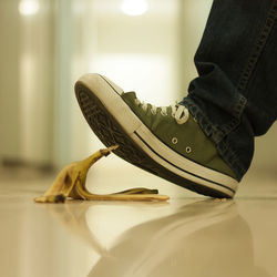 Low section of man over banana peel on floor