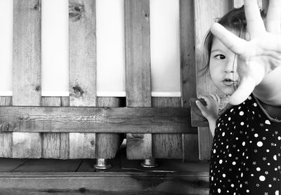 Girl showing stop gesture by wooden railing