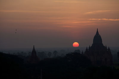 Silhouette temple against sky at sunset