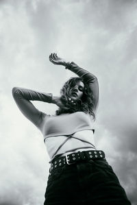 Low angle view of woman standing against sky
