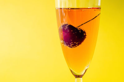 A glass of sparkling rose wine with cherry fruit served as a welcome drink. summer drink concept.