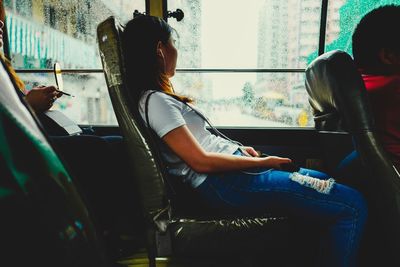 Side view of woman sitting in bus