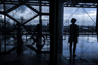 Rear view of silhouette woman standing at airport