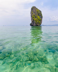 Scenic view of rocks in sea against sky