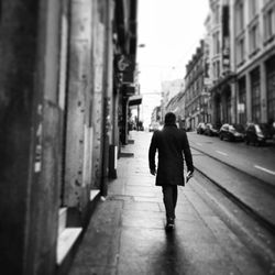 Rear view of woman walking on road