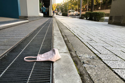 People on sidewalk by street in city