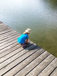 High angle view of boy on pier over lake