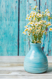 Close-up of yellow flower pot on table