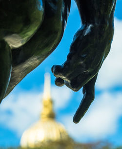 Low angle view of buddha statue against sky