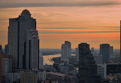 Modern buildings against sky during sunset