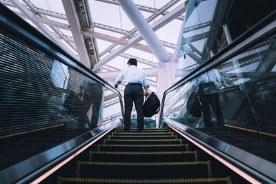 Low angle view of man on escalator