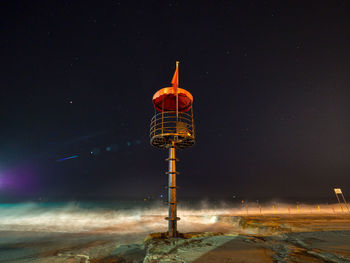 Low angle view of illuminated snow against sky at night