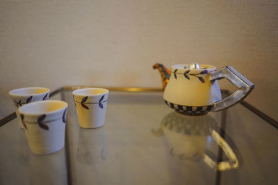 Close-up of coffee cup on table against wall at home