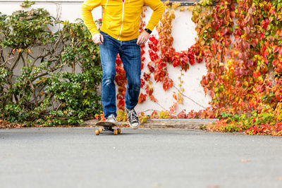 Low section of man skateboarding on road