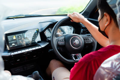 Midsection of woman holding camera in car