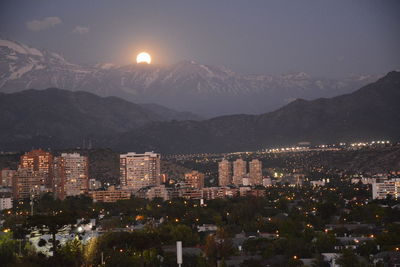 Illuminated cityscape against sky at night