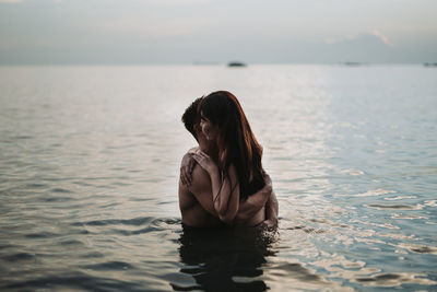 Woman looking at sea against sky