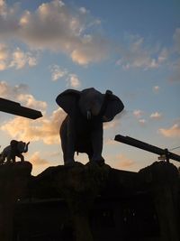 Low angle view of sculpture against cloudy sky