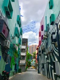 Street amidst buildings against sky in city