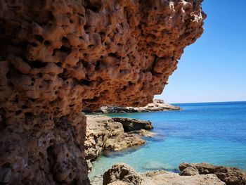 Scenic view of rock formation in sea against sky