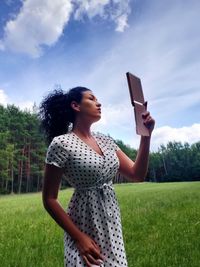 Young woman using mirror 