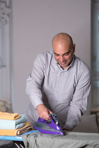 Man ironing clothes at home