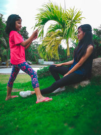 Full length of mother and daughter on plant