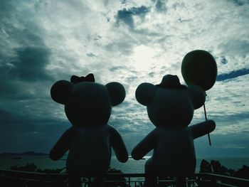 Silhouette of children against sky during sunset