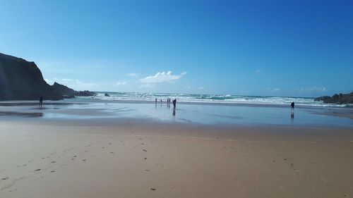 Scenic view of beach against blue sky