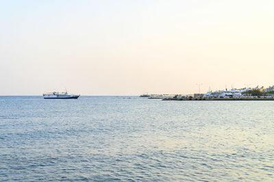 Sailboat sailing on sea against clear sky