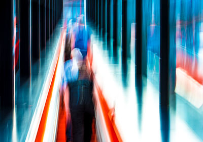 Woman walking on illuminated subway station