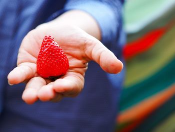 Close-up of hand holding strawberry