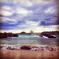 View of beach against cloudy sky