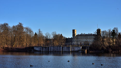 View of river and buildings against blue sky