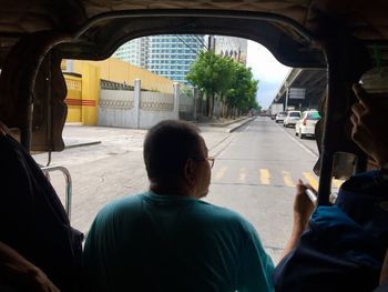 Rear view of man traveling in bus