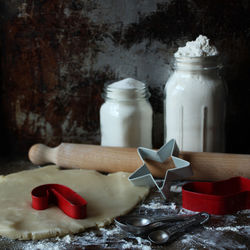 Close-up of cookie dough with pastry cutter and rolling pin on table