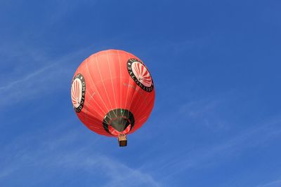 Low angle view of balloons against clear blue sky