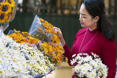Close-up of woman choosing bouquet at market