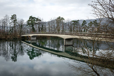 Arch bridge over river against sky