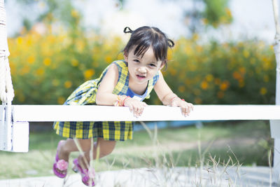 Portrait of young woman sitting on railing