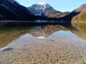 Scenic view of lake by mountains against sky