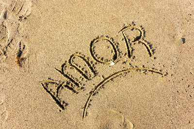 High angle view of text on sand at beach. amor