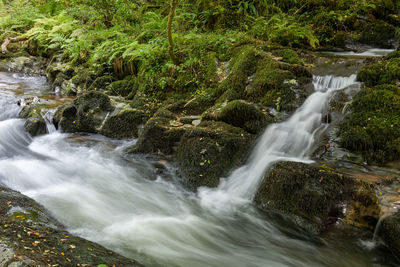 View of stream flowing through rocks