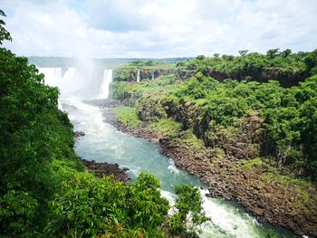 Scenic view of iguazu waterfalls and rainforest against sky
