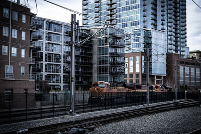 Railroad tracks in city against sky