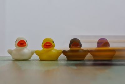 Close-up of toys on table against white background